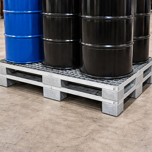 heavy-duty-metal-pallet-carrying-load Strong metal pallet carrying a heavy load of industrial drums.